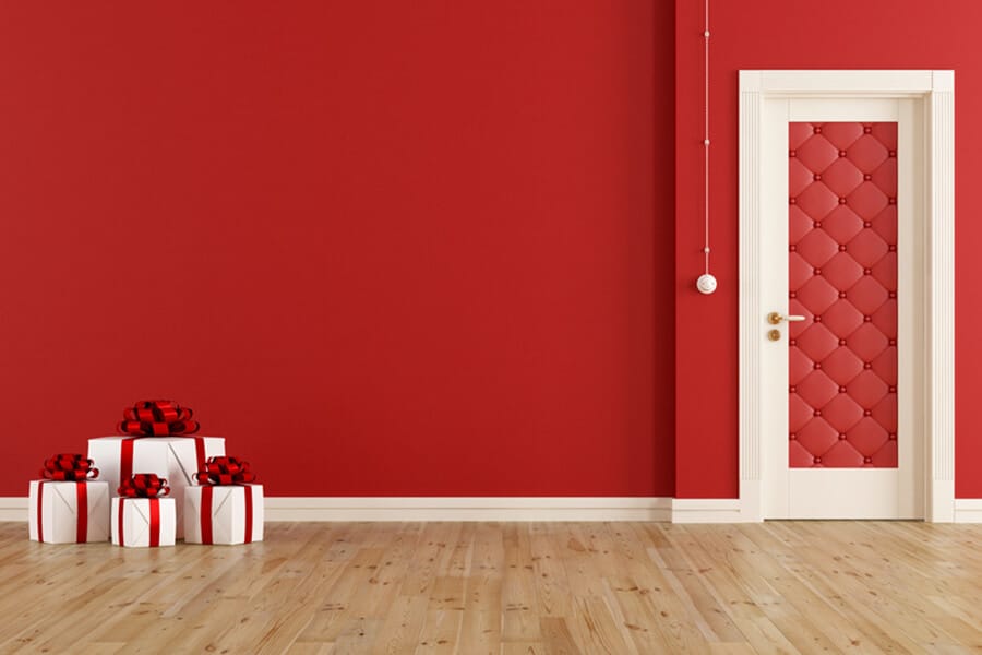 Porte rouge sur mur rouge et cadeaux de Noël