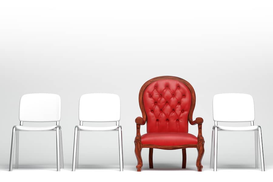 Alignement de 3 chaises blanches et 1 fauteuil rouge : le branding pour être différent
